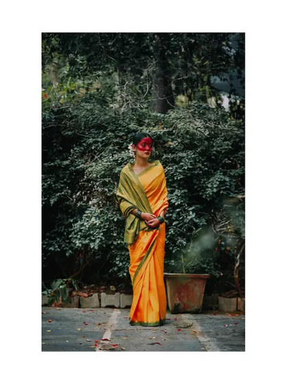 A full-length shot from the "Essence of Haldi" concept, showing the model in a serene pose against a lush green background.