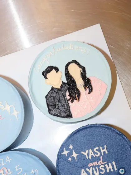 A close-up of the hand-piped couple's portrait from our engagement bento cake set. We use frosting to create a minimalist and modern illustration that captures the essence of the couple.