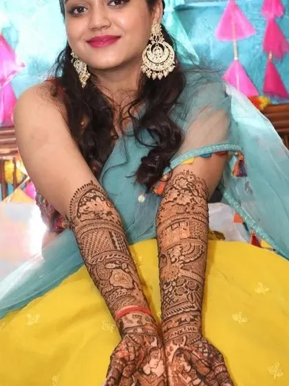A full view of the bride's stunning mehndi, covering her arms from fingertips to elbows in a rich tapestry of traditional art.