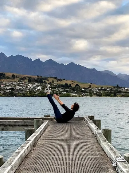 Our founder doing a teaser on a dock in Queenstown, proving that you can take your Pilates practice and strength anywhere in the world.