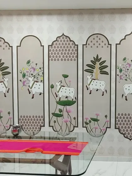 A custom Pichwai-style wallpaper installed in a dining area in Goregaon. The design features holy cows and lotus flowers arranged in decorative panels, adding a traditional and spiritual touch.