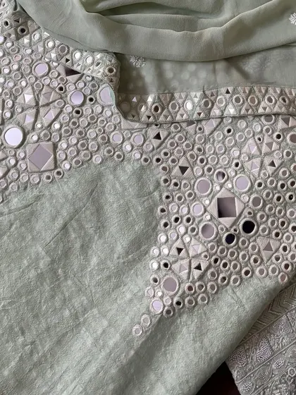 A close-up of the palazzo's hem, where intricate mirrorwork provides a striking contrast to the delicate Chikankari on the kurta.