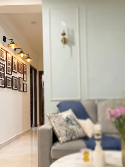 A welcoming living room space where a gallery wall of family photos is highlighted by industrial-style sconces, creating a warm and personal focal point.