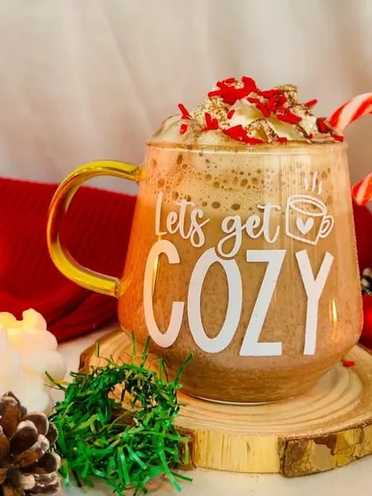 Let's get cozy. This glass mug with a gold handle is perfect for your favorite warm holiday beverage, complete with whipped cream and a candy cane.