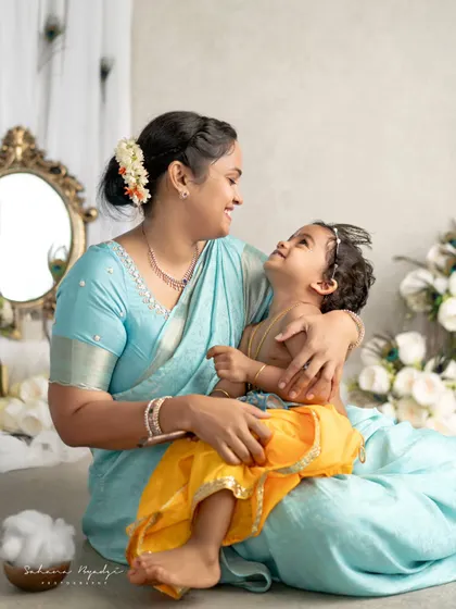 A beautiful, loving gaze between a mother and her son, both dressed in stunning blue and yellow outfits for their Krishna photoshoot. The connection between them is palpable.
