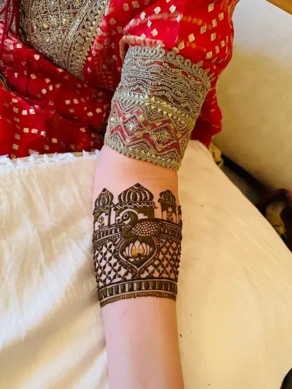 A close-up of an armband featuring a peacock and jharokha design. This shows how even a small section of the arm can be a canvas for detailed art.