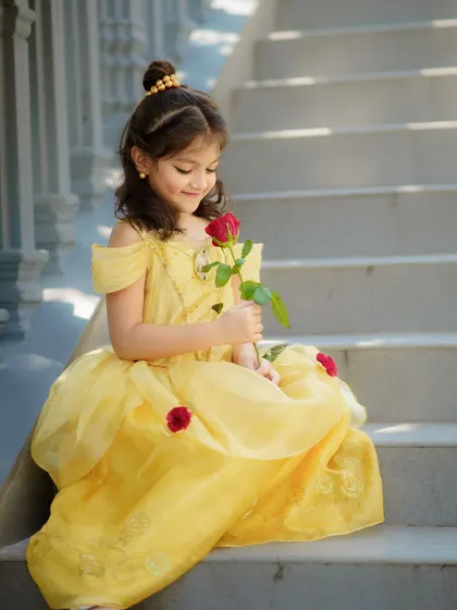 The prettiest Princess Belle on the steps of her castle. The grand staircase and her beautiful yellow gown create a truly cinematic moment.