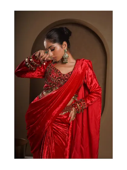 A close-up showing the detail on the full-sleeve blouse and the drape of the red velvet. This shot is perfect for highlighting the unique texture and craftsmanship.