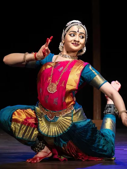 A flexible and dynamic pose from the Kanasu festival, showcasing the physical demands of the art form.