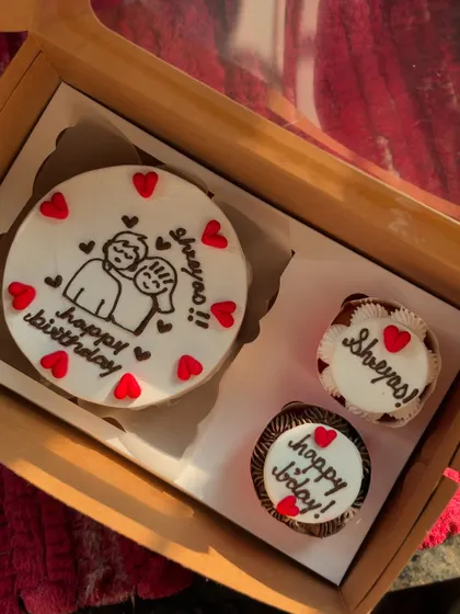 A sweet birthday gift for Shreyas, this set includes a bento cake with a cute cartoon couple and two personalized cupcakes. The red heart details tie the whole theme together perfectly.