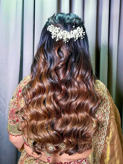 A classic bridal hairstyle with soft curls and a baby's breath hair accessory for an elegant touch.