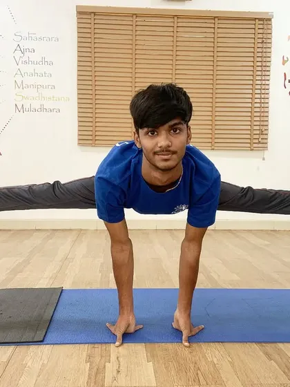 A young student achieves a full split using two stools for support, an inspiring display of dedication.