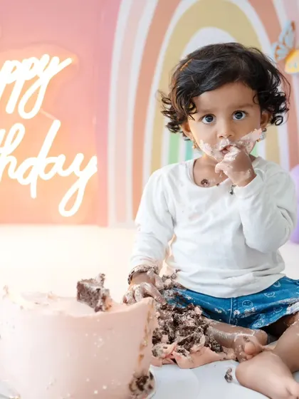 Another adorable shot of the birthday girl enjoying her cake. The focus is on her happy expression and messy hands.