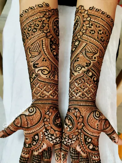 This is a beautiful example of full-coverage mehendi with dense, intricate patterns. The design is packed with detail, from the fingertips to the elbows.