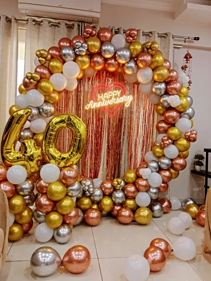 A stunning 40th anniversary or birthday celebration with a full balloon ring in rose gold, gold, and silver, a shimmer backdrop, and large '40' foil balloons.