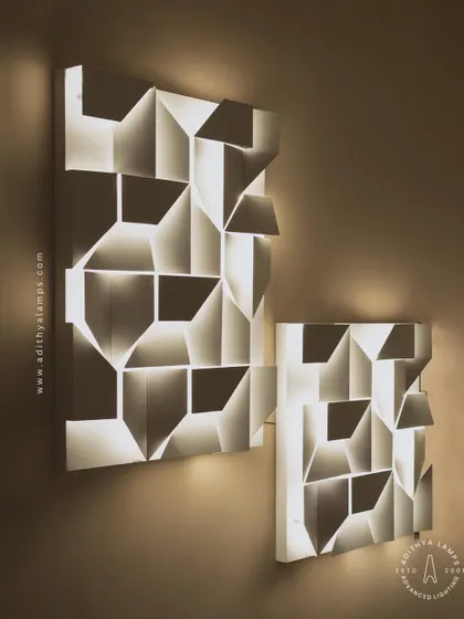 This 3D geometric wall light plays with light and shadow. The puzzle-like arrangement of white panels creates pockets of light, turning a simple wall into a dynamic feature. It is a perfect piece of illuminated wall art.