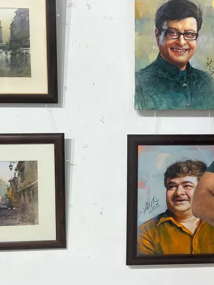 A happy moment, standing with some of my framed portraits and landscapes at an exhibition.