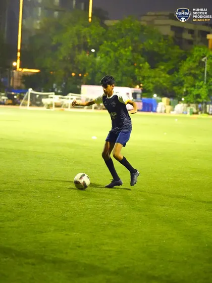 Close control is key. A young player keeps the ball tight to his feet while dribbling.