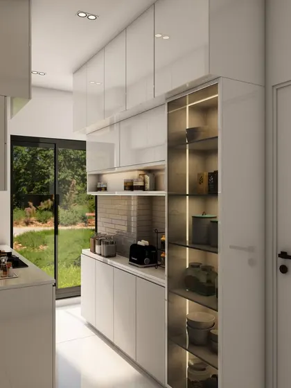 A view down the length of the minimalist white kitchen, emphasizing the seamless design and the bright, open feel.