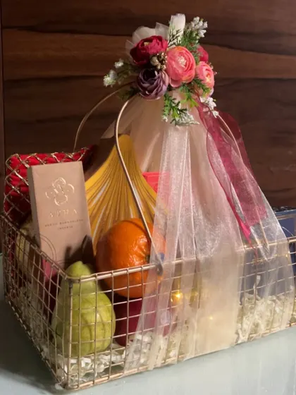 A festive fruit and gift basket created for Ganesh Chaturthi celebrations, wrapped elegantly with a floral arrangement on top.