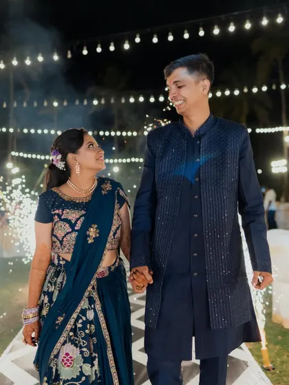 The couple shares a look of love during their Sangeet entrance, a beautiful, candid moment captured amidst the sparkling lights and celebratory atmosphere.