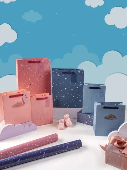 A whimsical and creative scene for Rae's children's gift wrap collection. The use of paper clouds and a sky-blue background creates a dreamy, imaginative world for the products.
