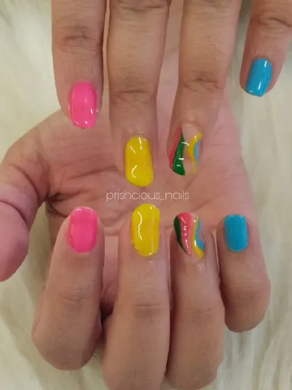 Bright and colorful vacation nails. This set features a mix of hot pink, yellow, and blue, with a fun multi-color swirl accent nail.