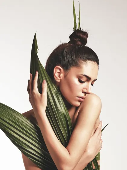 A softer moment from the leaf dress shoot. The focus is on the dewy skin and the way the natural leaves frame the face and body.
