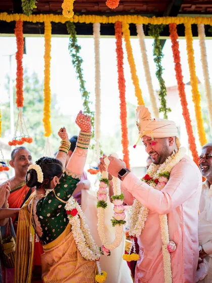 The bride and groom's playful competition during the garland exchange ceremony, a favorite moment for us to capture.