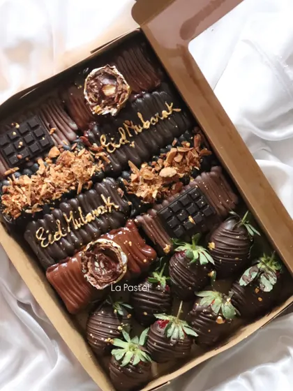 The complete Eid dessert box, filled with chocolate treats and chocolate-covered strawberries, perfect for sharing.