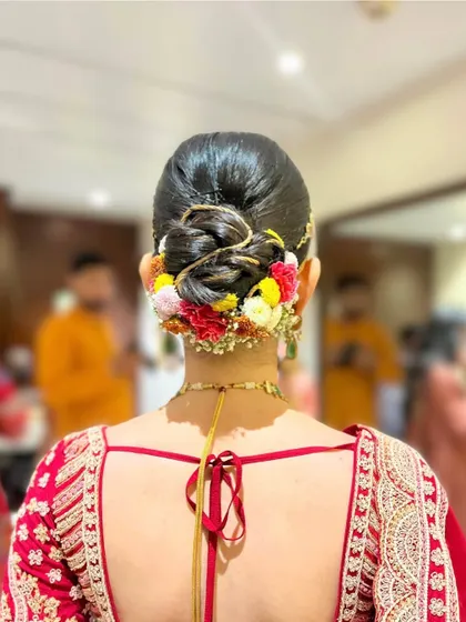 A colorful and vibrant floral bun, perfect for a daytime wedding or Haldi ceremony. The mix of flowers adds a playful and festive touch.