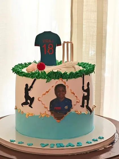A personalized cricket cake featuring an edible photo of the birthday boy, along with his favorite player's jersey number and cricket-themed decorations.