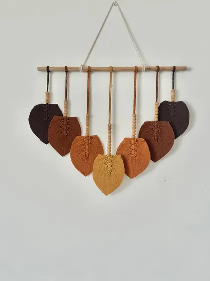 A custom macrame leaf hanging in beautiful shades of brown, from dark chocolate to light tan. The wooden beads add a lovely natural touch.