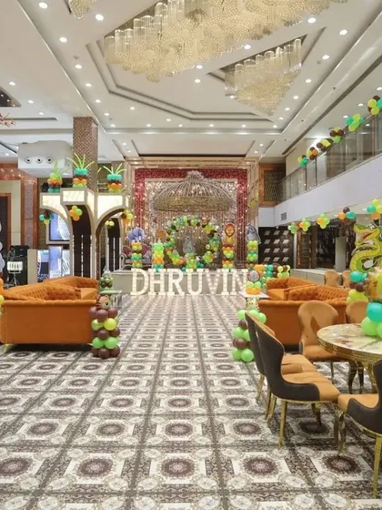 A wide shot of a large party hall decorated for a jungle-themed birthday, showing the scale of the event.