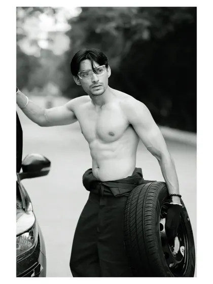 A conceptual men's fitness portrait. The black and white treatment accentuates the subject's physique and the gritty, determined mood of the shot.