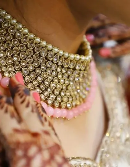 A detailed shot of a bride's kundan and pearl necklace, showcasing the beauty of her wedding jewelry.