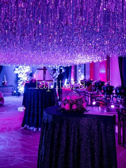 The party space illuminated in purple light, with a ceiling covered in shimmering silver tinsel creating a glamorous, starry effect.