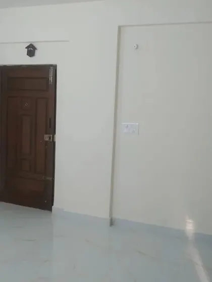 A simple room with clean off-white walls and a classic wooden door. Our painting service provides a neat and tidy finish for any residential space.