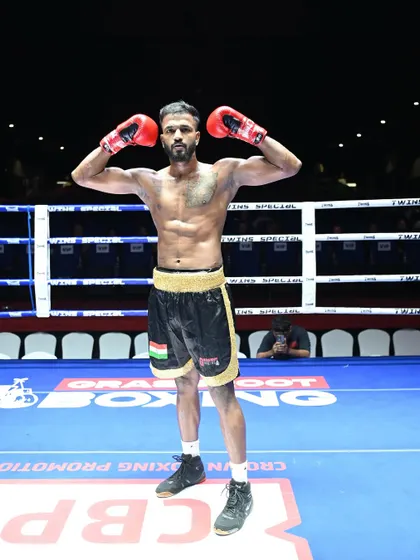 On top. A fighter poses in the ring after a victory, representing his home state of Tamil Nadu.