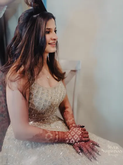 A candid shot of the bride getting ready, her hands showing the beautiful, dark stain of her mehndi.