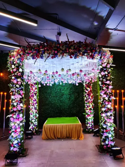 A beautiful and elegant floral mandap for a Ganesh Chaturthi celebration. The structure is covered in colorful flowers, creating a stunning home for the idol.