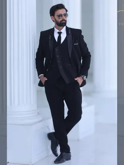 You can never go wrong with a classic. This is our bespoke all-black three-piece suit, custom-stitched for a sharp, flattering silhouette. It's a versatile and essential piece for any man's formal wardrobe.