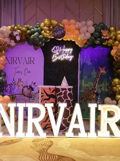 A bold and stylish jungle theme for Nirvair's first birthday. We used a dark backdrop to make the gold, green, and orange balloons pop, complemented by animal print plinths and a "Happy Birthday" neon sign.