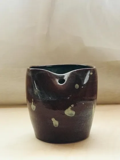 This "Sip Buddy" features a rich, dark glaze with light speckles, like a starry night. It's a small piece of magic for your daily drinks.