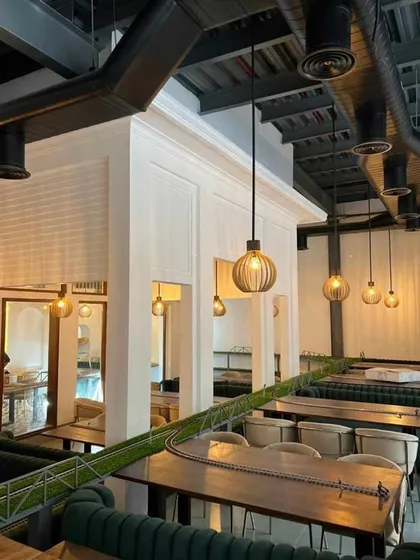 This view of the Kritunga restaurant project highlights our approach to commercial interior design, creating a unique dining atmosphere. We used industrial-inspired pendant lighting, exposed ductwork, and custom seating to craft an experience that reflects the restaurant's brand and vision.