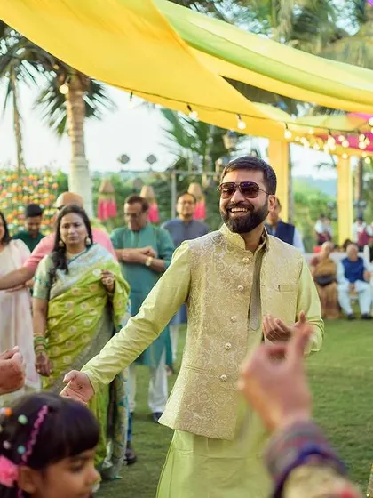 The groom making his way through the crowd, dancing and greeting guests.