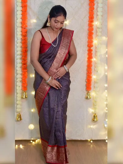Here I am, styling my mom's 35-year-old reception saree. This checked silk saree with a rich red and gold border is a timeless piece. It feels so special to wear something with so much history.