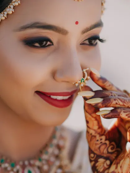 This artistic close-up captures the essence of a bride's final moments of preparation. The bold red lip and defined eye are classic choices that you will learn to perfect.