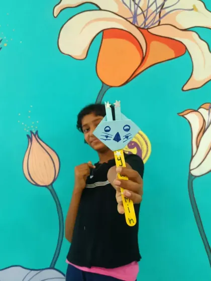 A young girl proudly displays her bunny craft. After a story session, these activities help children connect with the story's themes on a deeper level, turning abstract ideas like hope and rebirth into something they can hold.
