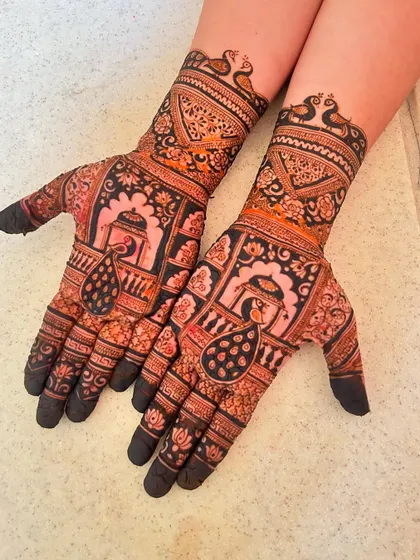This intricate design features peacocks and jharokha windows, using a mix of fine lines and bold-filled sections to create depth and contrast.